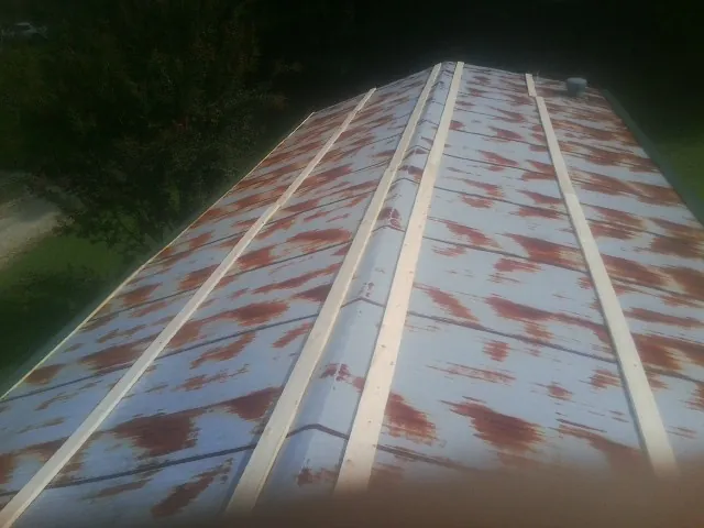 Rusted metal roof panels with new wood purlins before replacement — Storm Damage Roof Repair in South Sioux City by Roofing Brothers