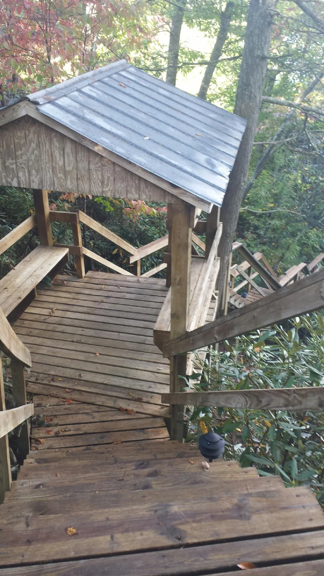 Metal roofed shelter over wooden steps on a wooded walkway — Skylight Repair & Installation work by our crew in South Sioux City