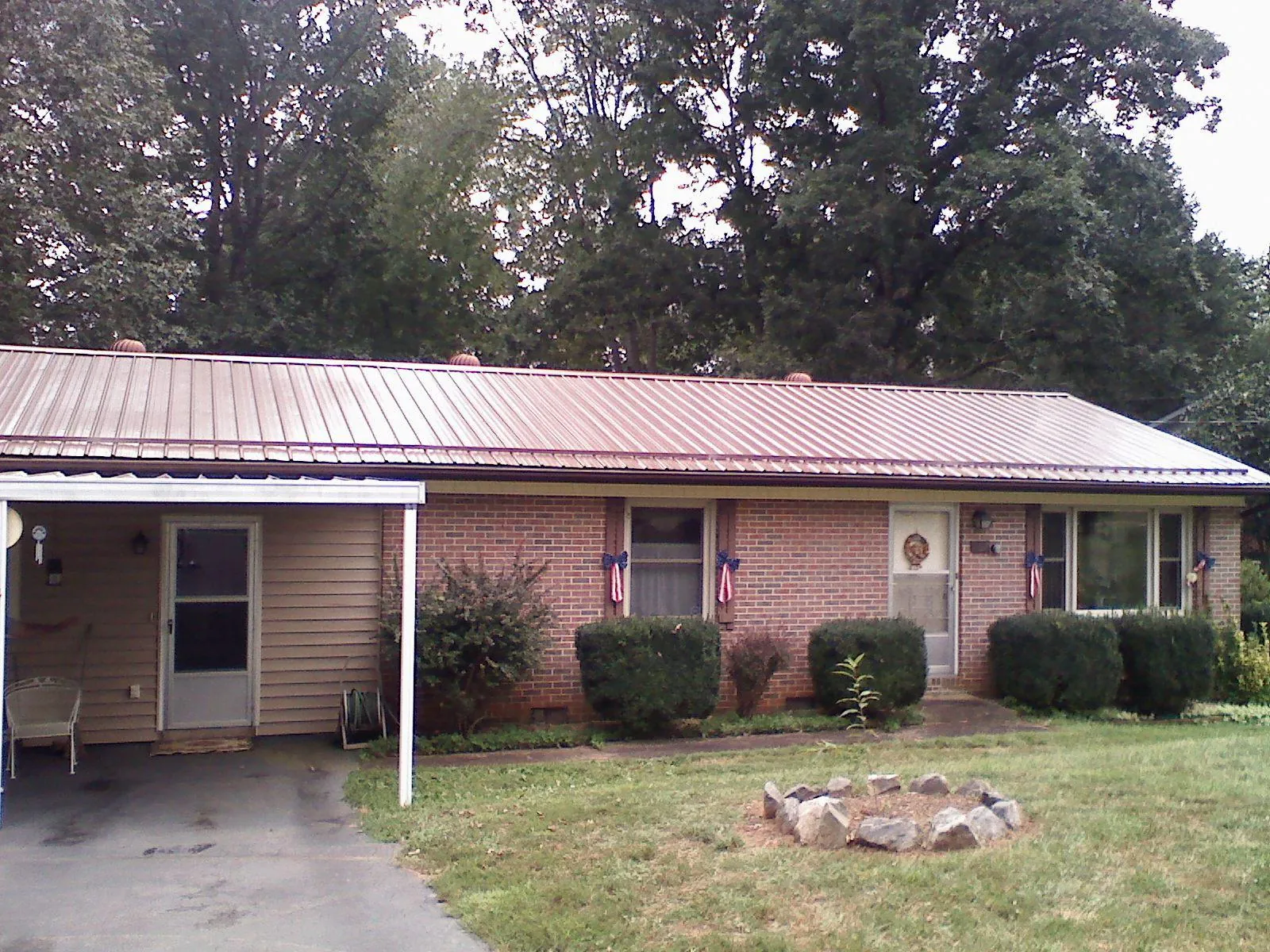 Bronze metal roof and carport on a brick ranch home — Roof Repair work by our crew in South Sioux City